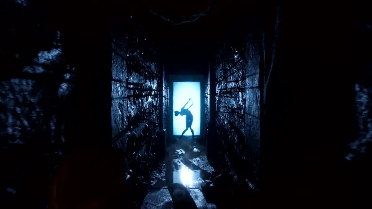 A figure silhouetted in a bright doorway at the end of a dark Labyrinth tunnel